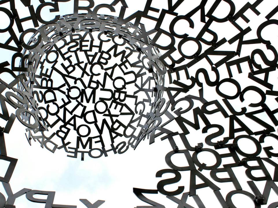View of the sky through a structure of black letters that are all connected with each other. A sculpture by Jaume Plensa viewed from the inside.