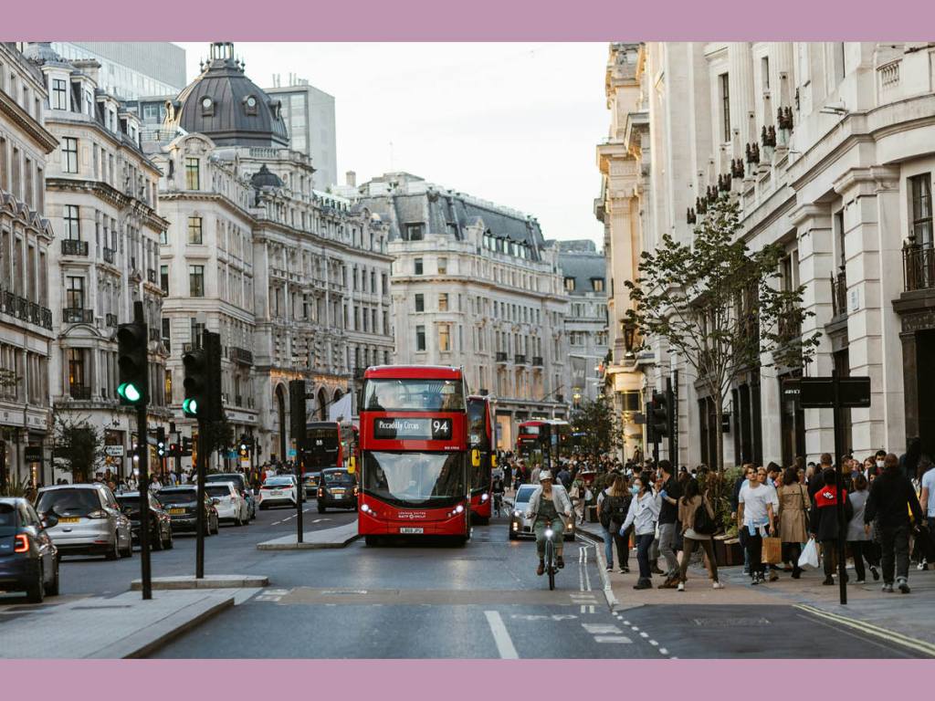 View of a busy street in London and a red bus making its way towards the viewer