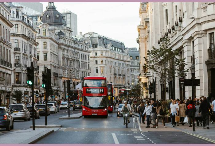 View of a busy street in London and a red bus making its way towards the viewer